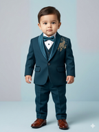1-year-old baby boy wearing a premium teal blue tuxedo with gold Aari deer embroidery on the shoulder and satin shawl lapels.