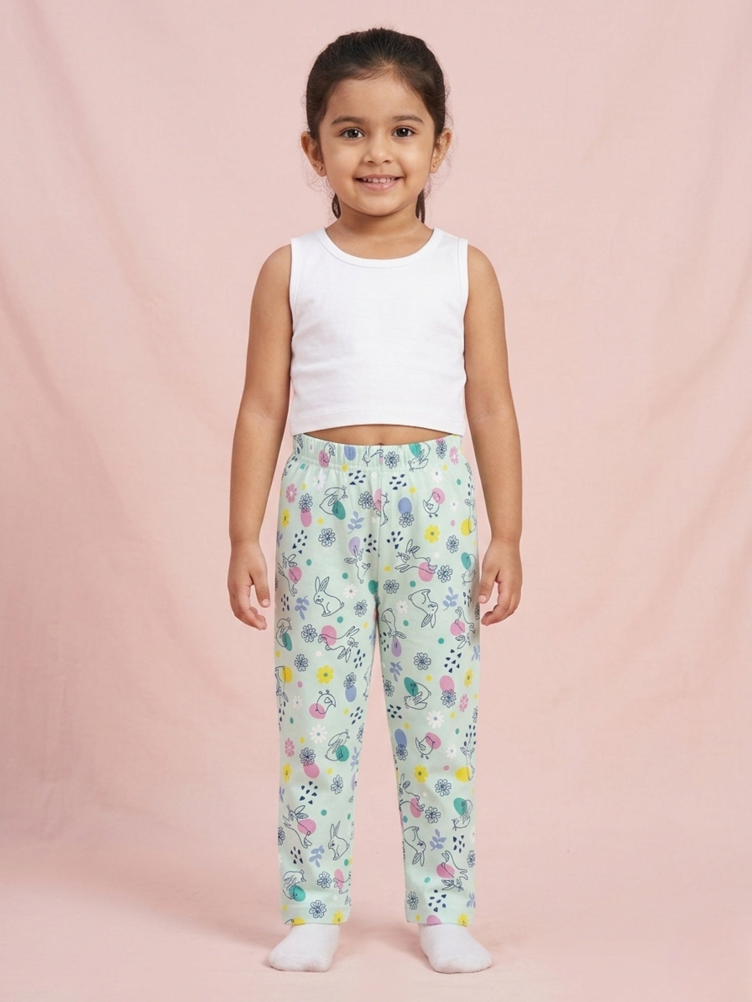 Toddler girl wearing mint green cotton pajama pants with a white bunny and yellow floral print.