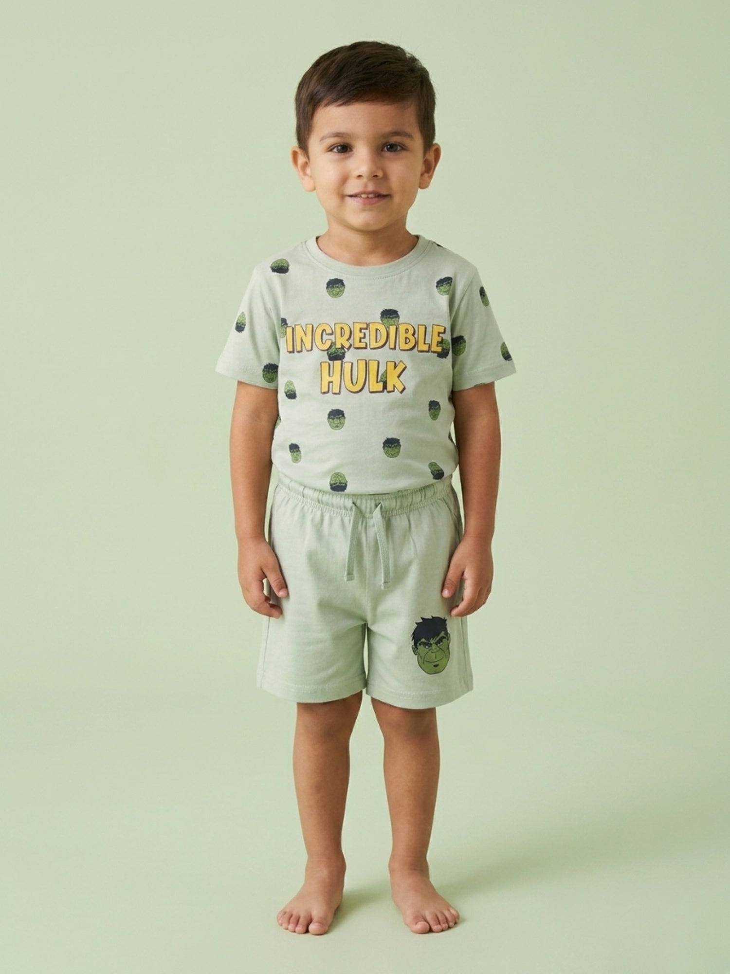 Young boy standing in a mint green two-piece cotton set featuring an Incredible Hulk printed t-shirt and matching shorts with a Hulk character graphic.