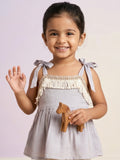 Young girl in a lilac/grey sleeveless top featuring white fringe detailing and adjustable tie-up shoulder straps.