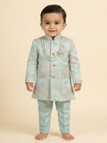 Toddler boy wearing a mint green embroidered sherwani with traditional dhoti and pearl necklace.