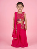 Little girl in a bright fuchsia pink ethnic outfit featuring a multi-color embroidered crop top and matching palazzo pants with an embroidered pocket detail.