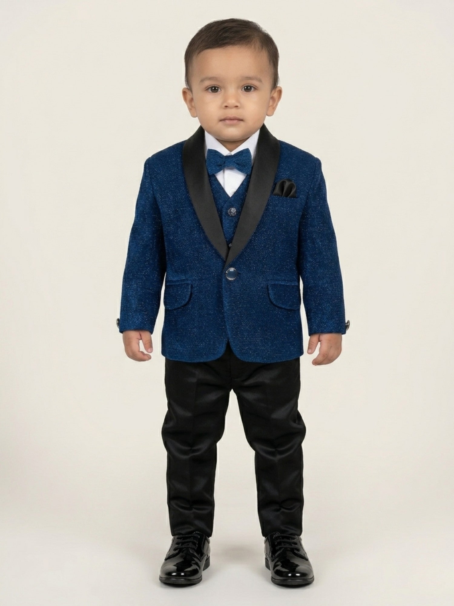 Baby boy wearing navy blue premium formal suit set with matching blazer and pants, white shirt, red bow tie, and pocket square for partywear occasions.