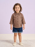 A young girl smiling while wearing a mocha brown long-sleeve button-down blouse featuring a large, intricate lace Peter Pan collar and matching lace side-panel accents.
