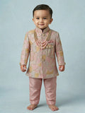Toddler boy wearing a rose pink designer sherwani with a traditional embroidered dhoti.