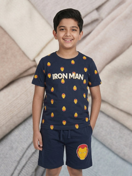 Young boy smiling in a navy blue two-piece cotton set featuring an Iron Man printed t-shirt and matching shorts with a large Iron Man mask graphic.