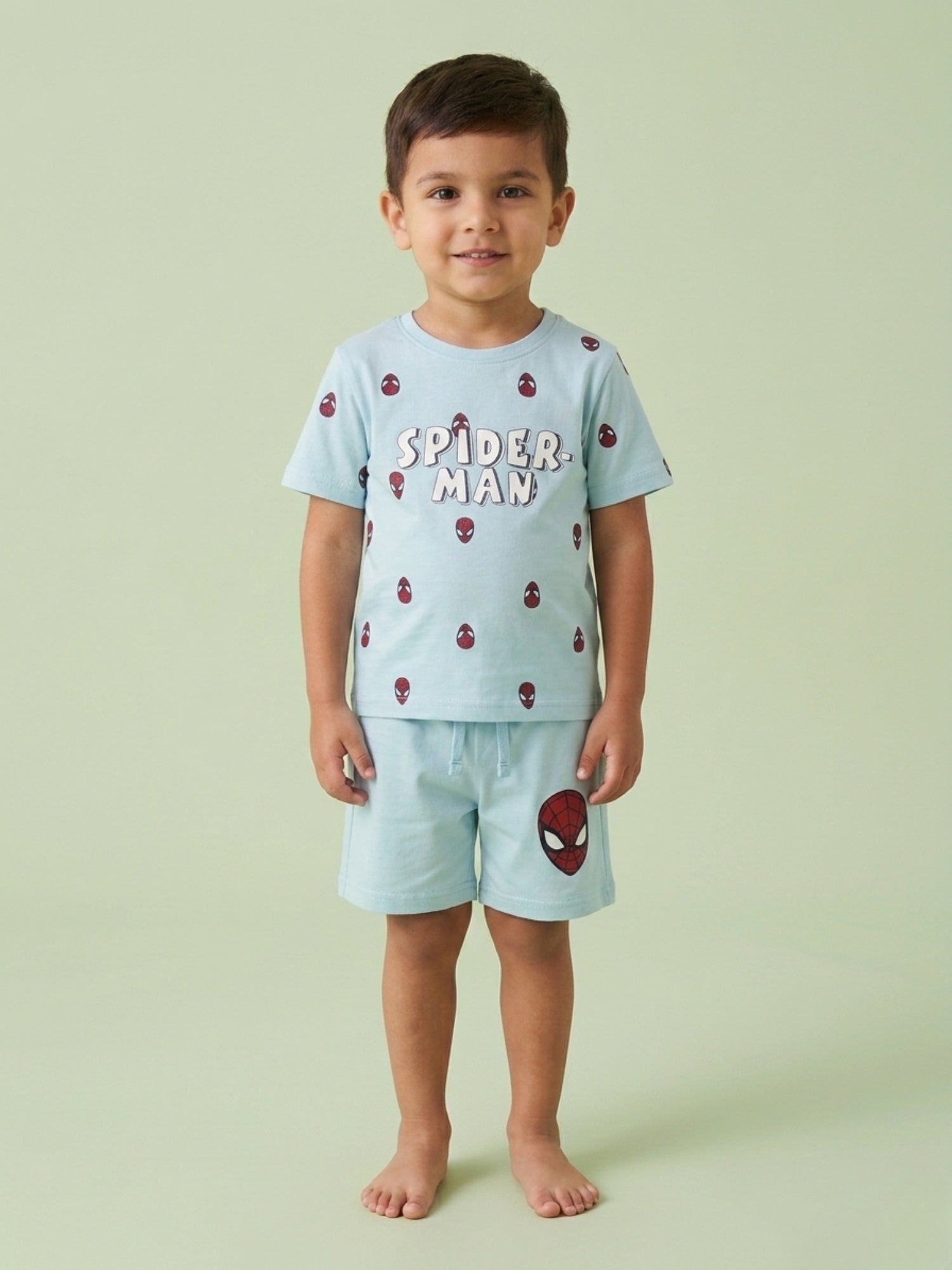 Young boy standing in a sky blue two-piece cotton set featuring a Spider-Man printed t-shirt and matching shorts with a large Spider-Man mask graphic.