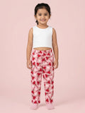 Girl wearing bright pink cotton pajama pants with a repeating red heart lollipop and white heart pattern.