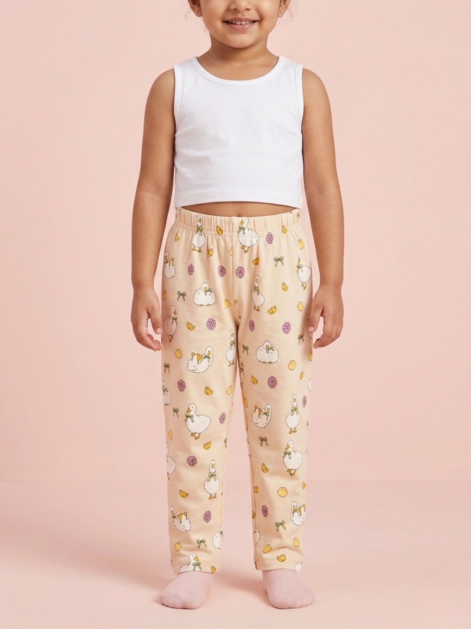 Toddler girl in soft peach cotton pajama pants featuring a cute yellow duck and chick pattern.